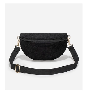 Detail of black corduroy belt bag showing soft ribbed texture and golden hardware
