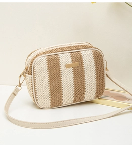 Close-up of woven straw camera bag featuring khaki stripes and golden hardware