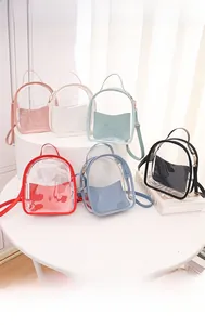 Detail view of mini transparent PVC backpacks in six pastel colors on white display stands