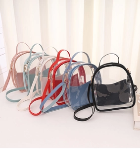 Detail view of mini transparent PVC backpacks in pink, blue, white, red, and black colors