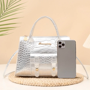 Silver crocodile texture handbag with metal logo and shoulder strap on woven mat
