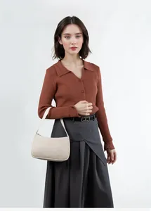 Close-up of a stylish beige shoulder bag with zipper detail on a fashion model