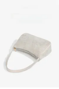 Detail view of a light gray suede shoulder bag with smooth leather trim and gold hardware
