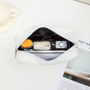 Minimalist white PU leather crossbody bag with gold zipper and embroidered floral strap