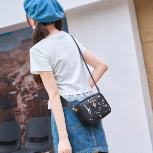 Black leather crossbody camera bag with flower embroidery and wide textile strap