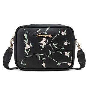 Black leather crossbody bag featuring floral embroidery and adjustable strap