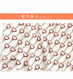 Close-up of leopard and equestrian bit patterns on silk satin square scarf detail