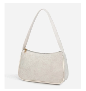 Detail of minimalist cream suede underarm bag featuring smooth leather trim and gold zipper