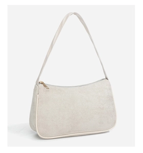Detail showing high-quality beige suede texture and smooth zipper on the crescent bag