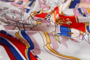 Close-up of nautical silk scarf featuring detailed anchor and sailboat patterns