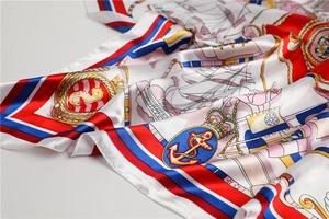 Close-up of nautical silk scarf featuring anchors, ropes, and vibrant satin texture