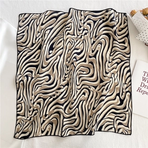 Detail of artistic zebra pattern silk square scarf with fine stitched edges and smooth texture