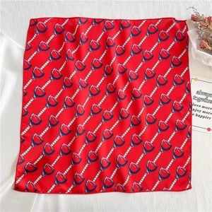Detailed close-up of red satin scarf showing chain and horsebit patterns with clean stitching
