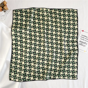Close-up of geometric houndstooth pattern satin scarf in yellow and green