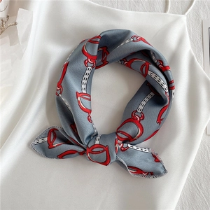Elegant gray square scarf with red bit and chain patterns tied in a silk bow