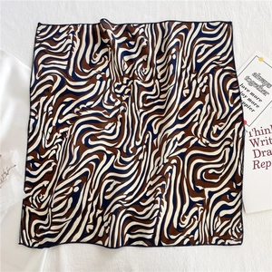 Detailed view of the zebra print satin scarf with fine stitching on white fabric