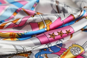 Detailed view of nautical silk scarf featuring vibrant cartoon patterns and smooth satin texture