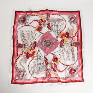 Flat lay detail of nautical square silk scarf with sailboats and anchors in coral pink