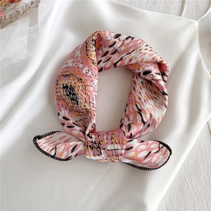 Close-up of pink satin floral square scarf with fine black stitching and abstract dots