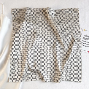 Detailed texture of satin neckerchief featuring elegant chain patterns and silky finish