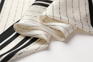 Macro shot showing elegant striped pattern and smooth satin texture of the square silk scarf