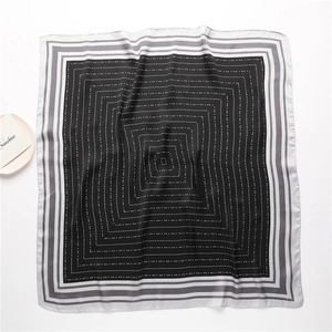 Detailed top view of a black 70cm square silk scarf with white dots and striped borders