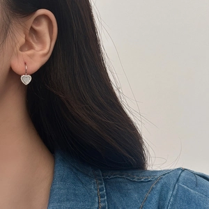 Gros plan de boucles d'oreilles cœur avec nacre et détails en pavé de zircones