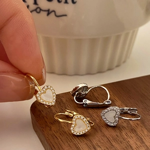 Boucles d'oreilles cœur élégantes avec zircons pavés et nacre sur socle en bois