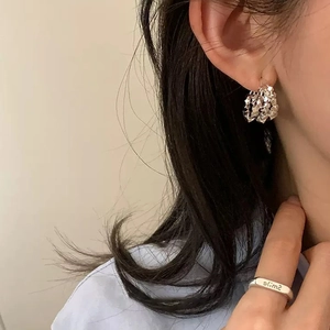 Silver layered textured earrings and smile engraved ring on model for elegant style