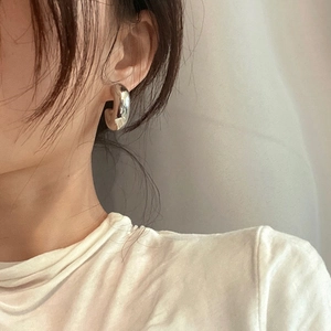 Boucles d'oreilles créoles épaisses en C argentées avec finition métal poli sur modèle