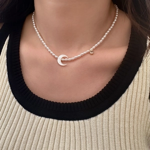 Collier de perles élégant pour femme avec un pendentif croissant de lune blanc et doré