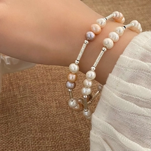 Elegantes mehrfarbiges Süßwasserperlen-Armband mit gebürsteten Silberröhren am Handgelenk