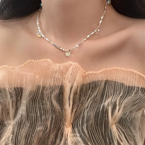 Detail of beaded choker necklace with silver metal cubes and crystal teardrop pendants