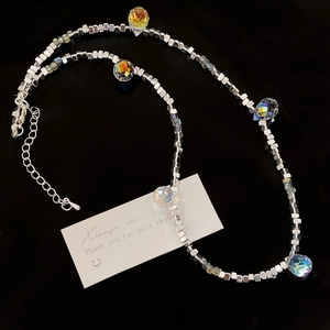 Macro shot of silver beaded necklace with iridescent crystal cubes and lobster clasp