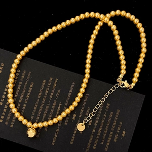 Detail of golden pearl necklace with sphere pendant and adjustable extension chain