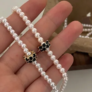 Comparaison de colliers de perles élégants avec boules dorées serties de cristaux noirs