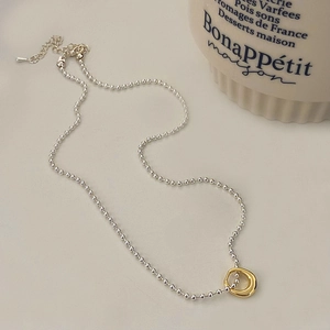Detail of silver ball chain and golden ring pendant with adjustable lobster clasp
