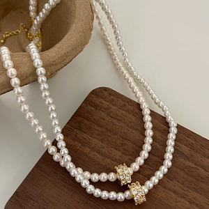 Collier de perles à double rang avec breloques dorées en zircone et fermoir