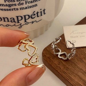 Detailed shot of hollow heart-shaped rings with zircon inlay in gold and silver finish