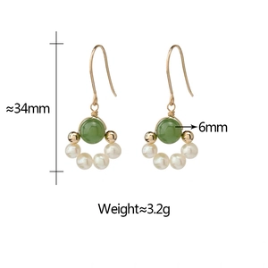 Detailed view of gold earrings with 6mm green beads and white freshwater pearls