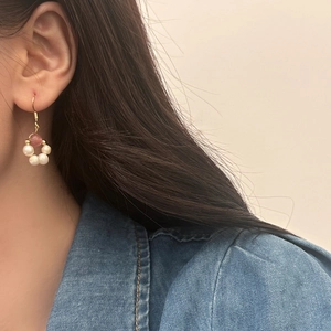 Elegant freshwater pearl and pink stone circular drop earrings worn by a model