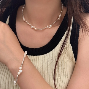 Close-up of French-style baroque pearl necklace and bracelet set on a model