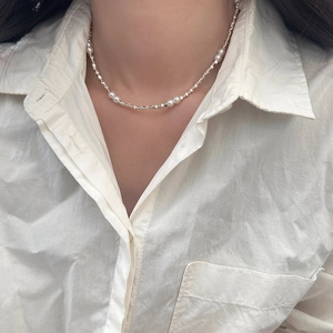 Detailed view of freshwater pearl necklace with silver blocks on model's neck