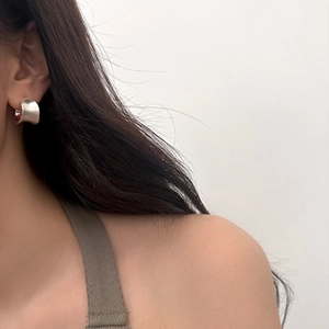 Side view of model wearing minimalist silver wide C-shape earrings with a matte brushed finish