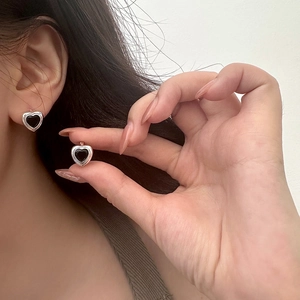 Détail des boucles d'oreilles vintage avec cœur en zircon noir et cadre argenté