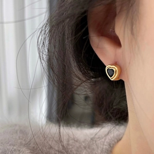 Gros plan de boucles d'oreilles cœur vintage avec zircon noir et cadre doré