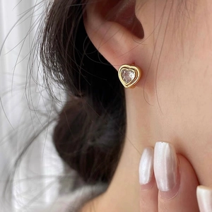 Boucles d'oreilles cœur vintage en or avec cristaux de zircon portées par un mannequin