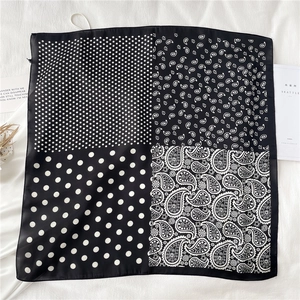 Détail d'un foulard en soie carré avec pois et motifs cachemire en noir et blanc
