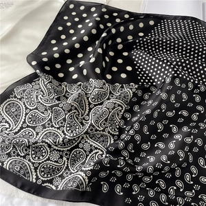 Détail d'un foulard en soie avec motifs paisley et pois en noir et blanc chic