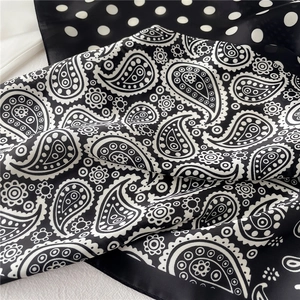 Gros plan d'un foulard en soie à pois et paisley montrant une texture fine